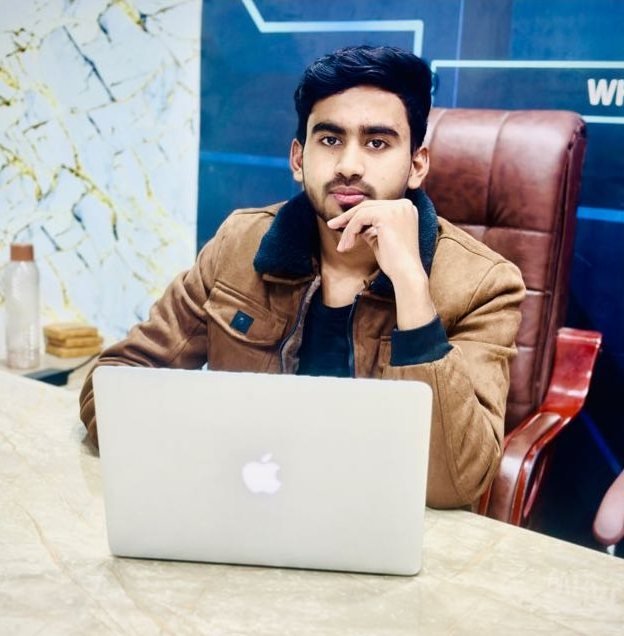 Aun, CEO of Aun Group of Companies and Ecommerce With Aun, sitting at a desk with a laptop
